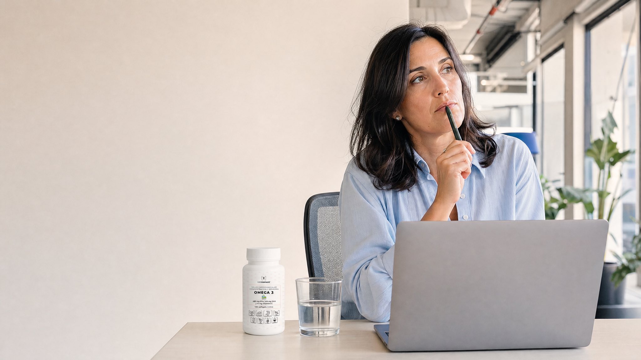 Mujer pensativa en la oficina junto al Omega 3 Labmoment